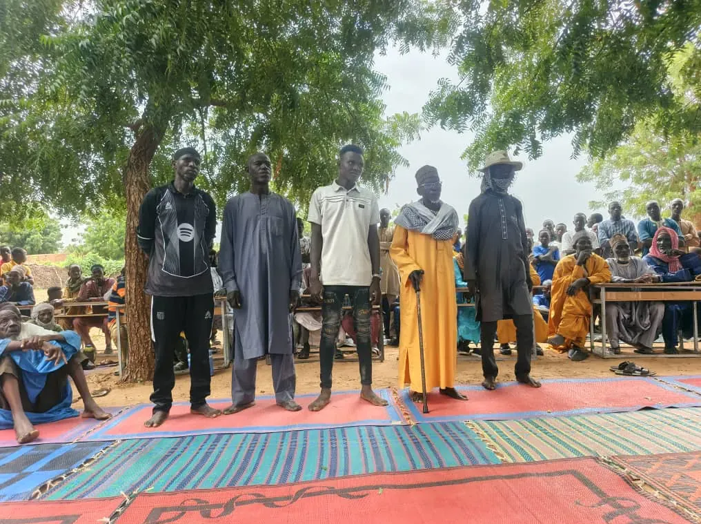 Représentants communautaires debout devant l’assemblée lors de l’activité de renforcement des capacités à Alfa Koira